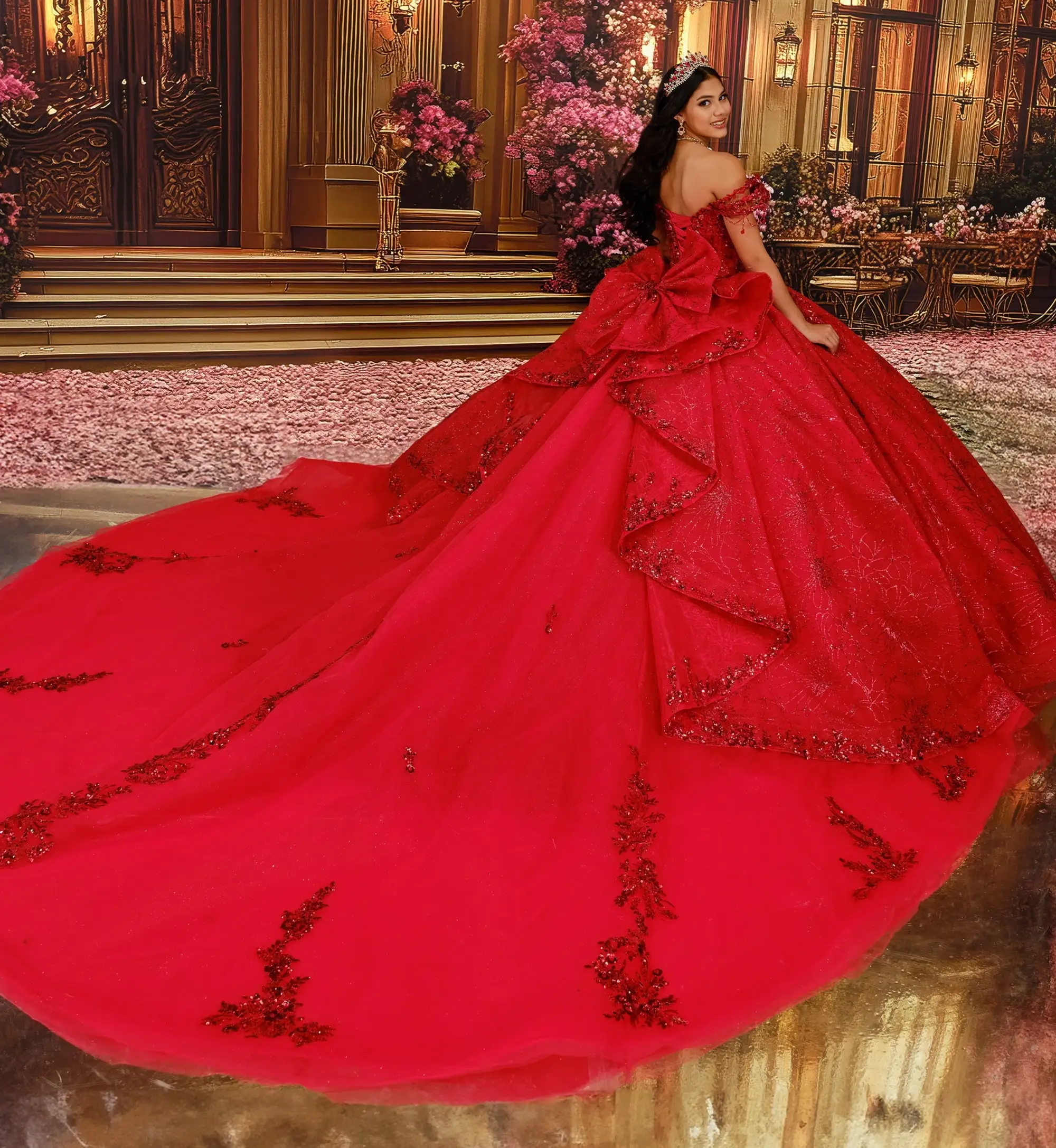 Una mujer, ataviada con un lujoso vestido rojo, permanece de espaldas al espectador, luciendo una elaborada cola adornada con intrincados detalles, enmarcada por el elegante tel&oacute;n de fondo de un gran sal&oacute;n repleto de flores.