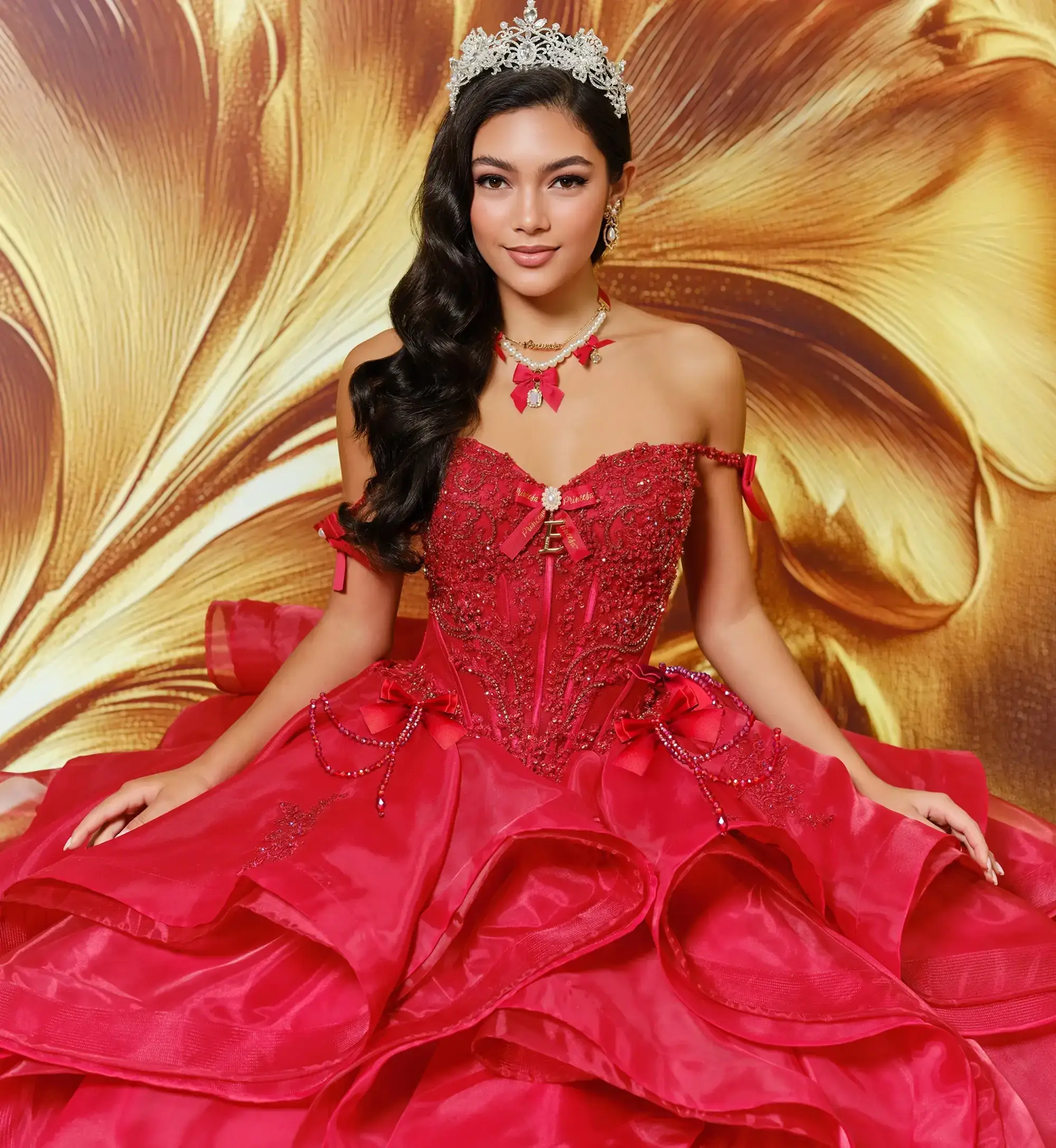 La modelo lleva un vestido rojo de quinceañera con hombros descubiertos.