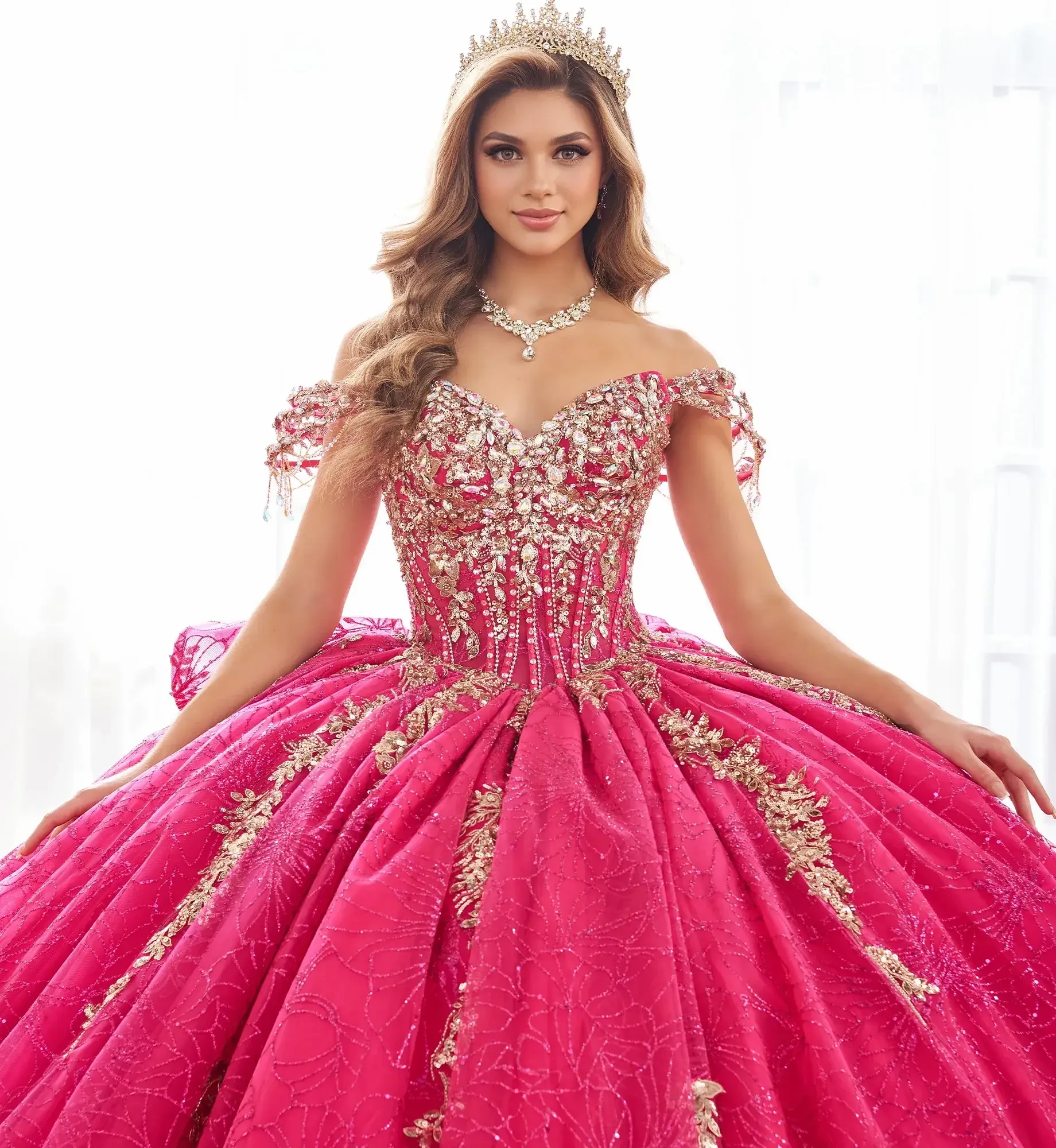 La modelo lleva un vestido de quinceañera magenta con dorado
