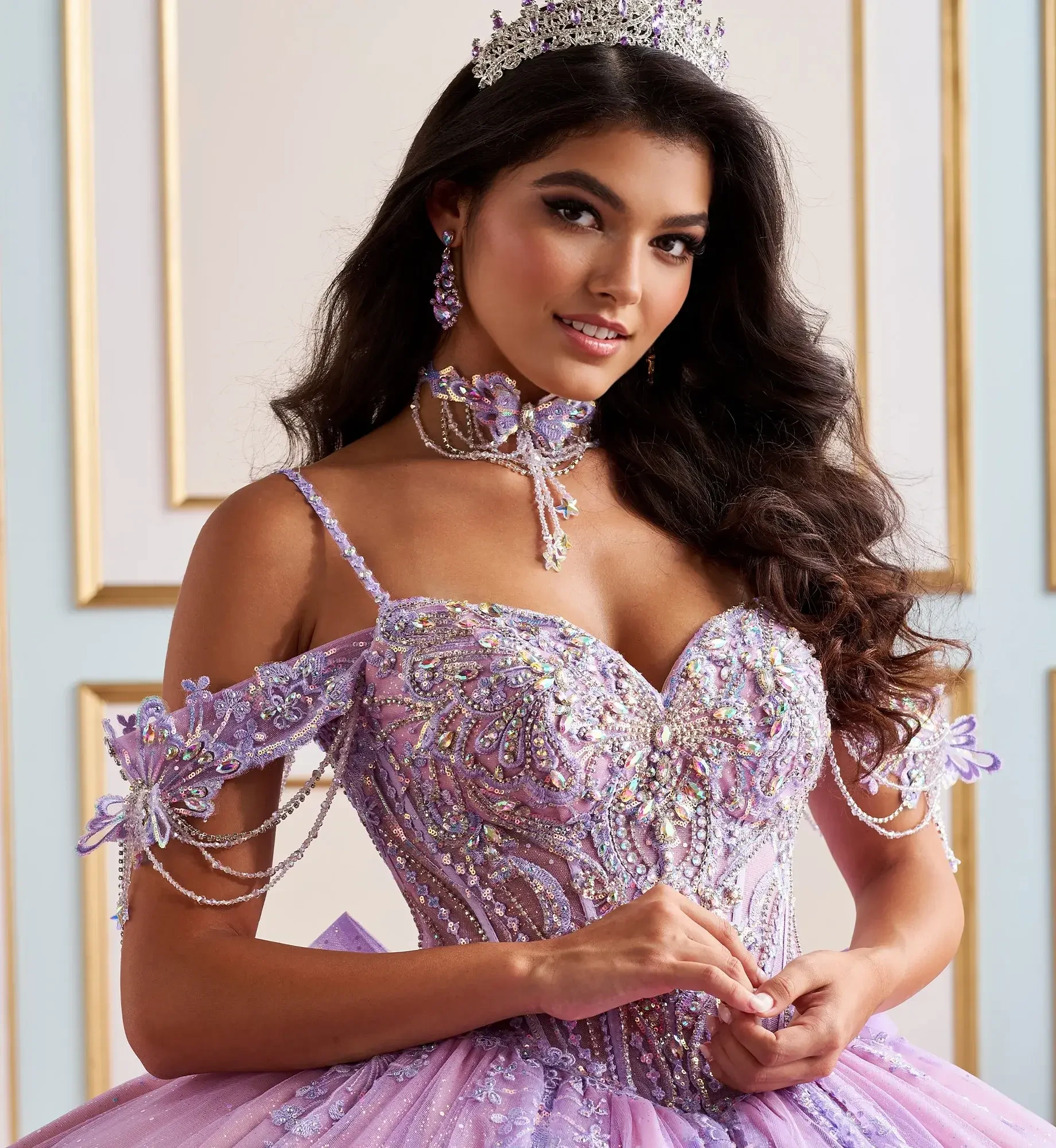 La modelo lleva un vestido de quinceañera lila con hombros descubiertos.