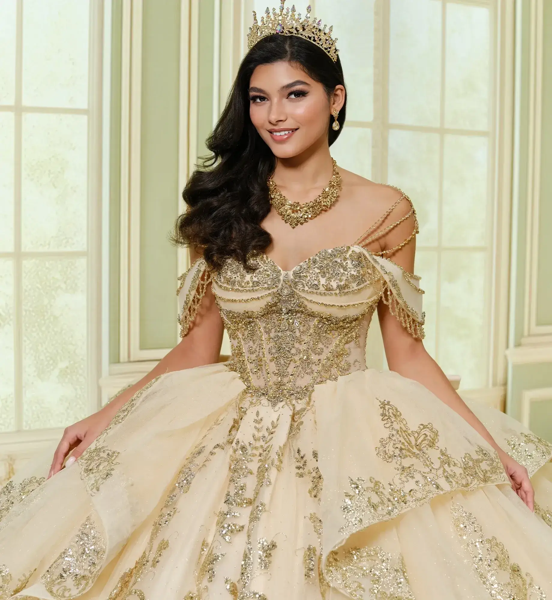 La modelo luce un vestido de quinceañera dorado champán con hombros descubiertos.