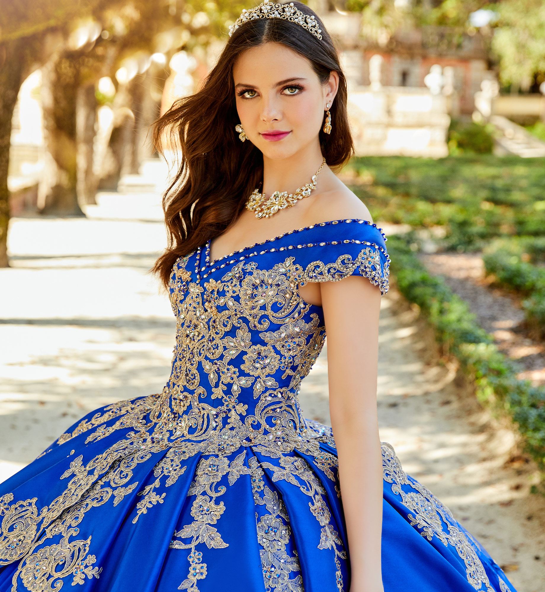 Brunette model in bright blue and gold quinceañera dress