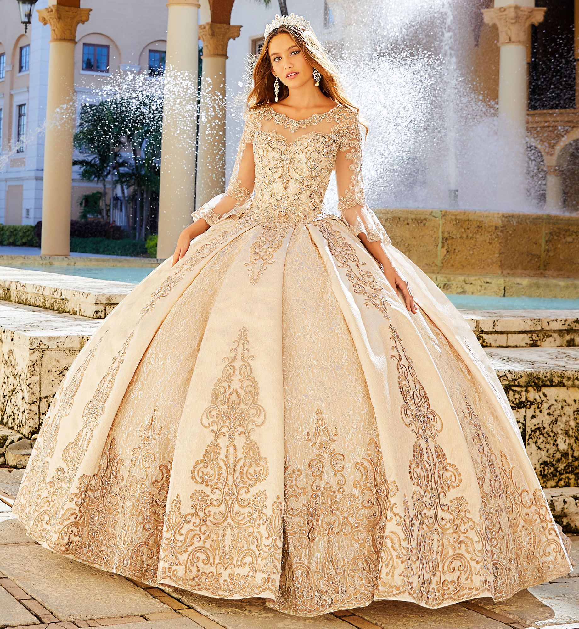 Brunette model in long sleeve sparkly gold quinceañera dress
